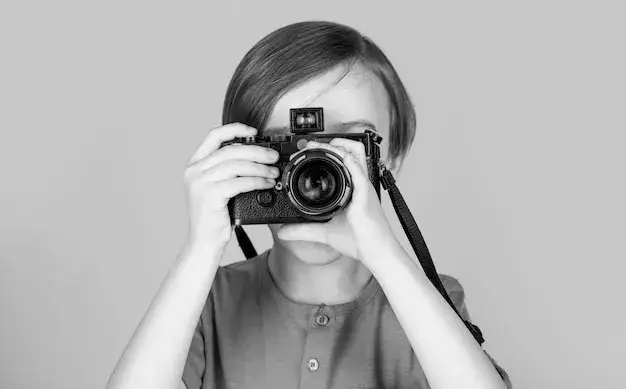 dziecko trzymające aparat fotograficzny